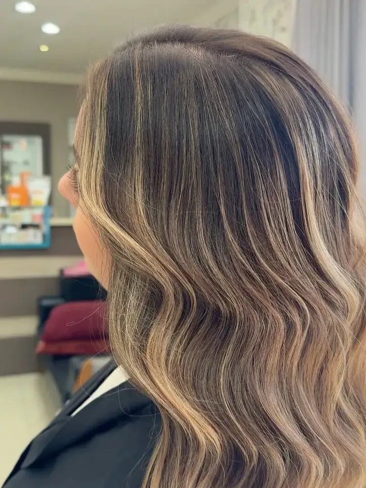 Cabelo iluminado com ondas, de costas, dentro do salão